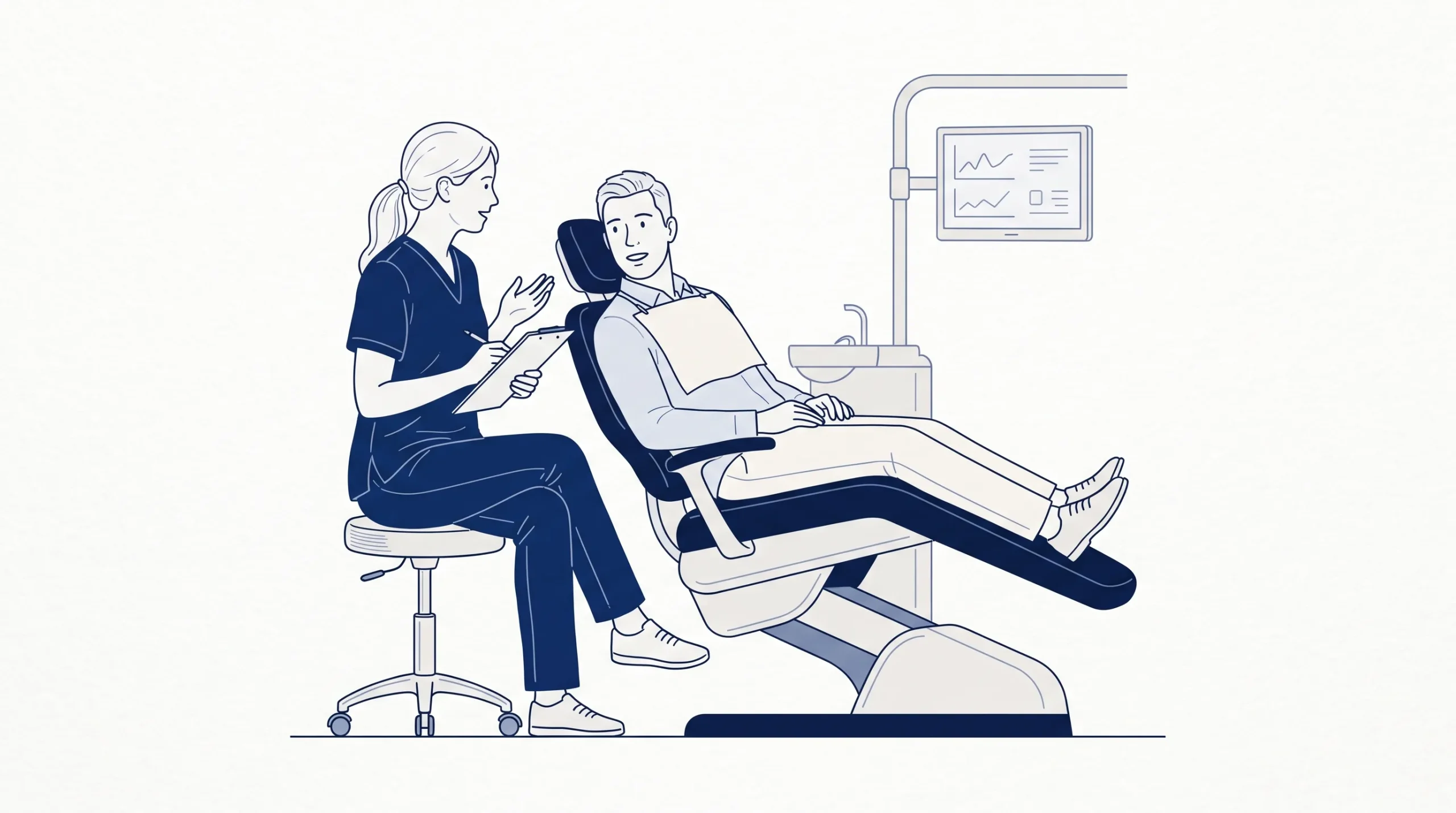 A dentist in clean scrubs sits beside an adult patient in the dental chair and talks through the first appointment before the examination.